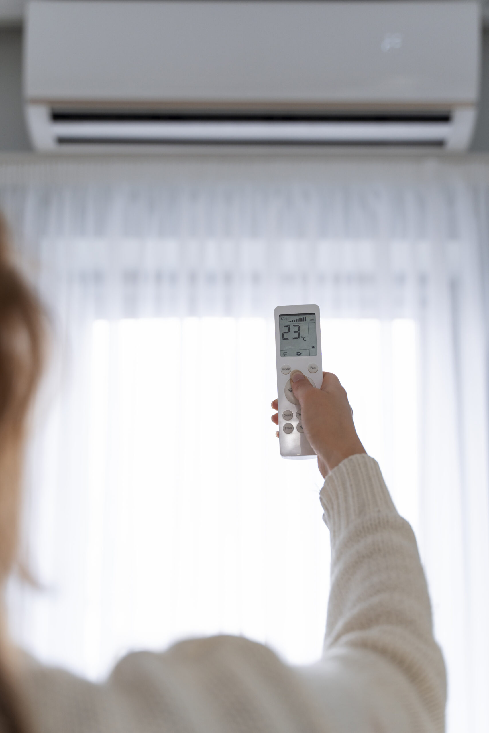 Femme controllant la température de sa maison avec une télécommande